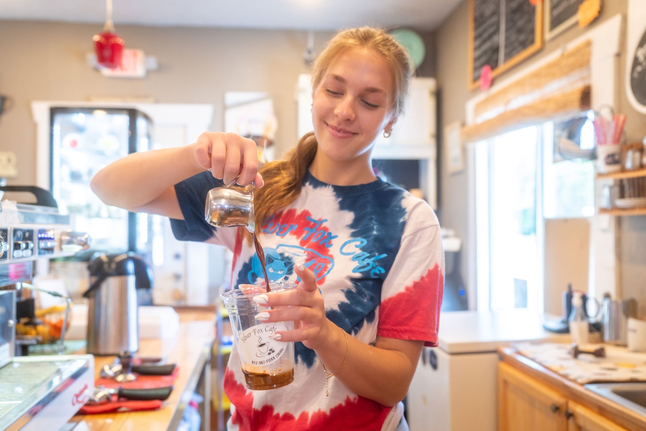 Employee pouring coffee at shop